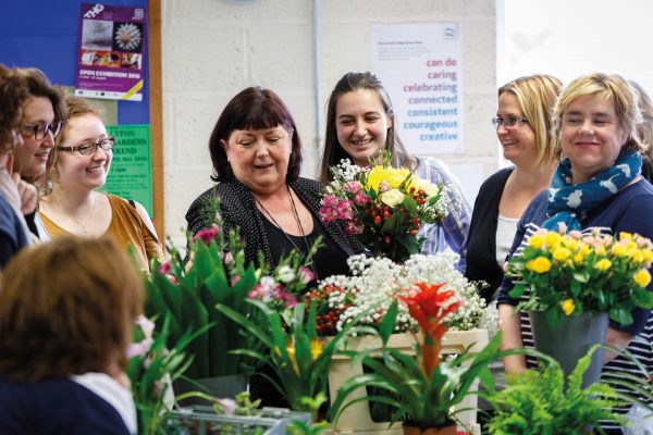Floristry students watching an arrangement demo from their tutor