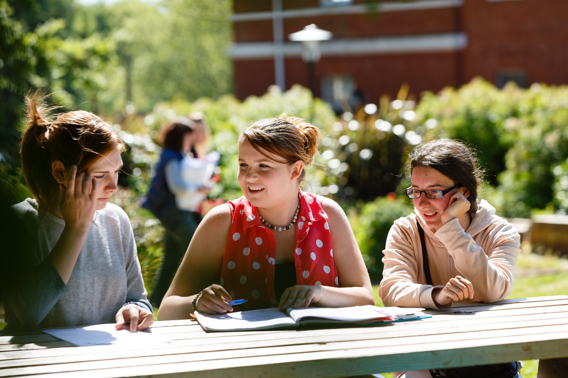 Student Area Three students chatting outdoors on campus