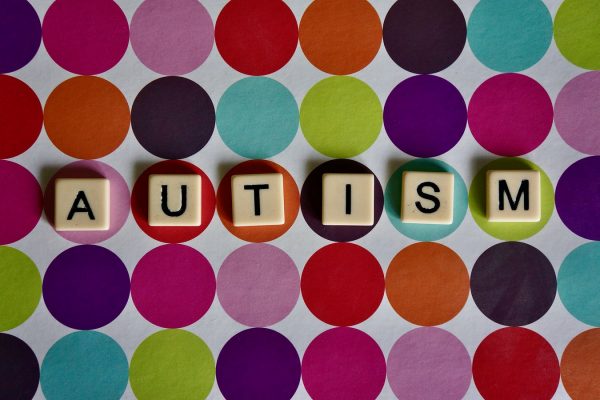 Autism word on lettered tiles with multi-coloured circle background