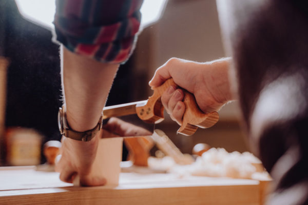 Carpenter sawing wood in a workshop